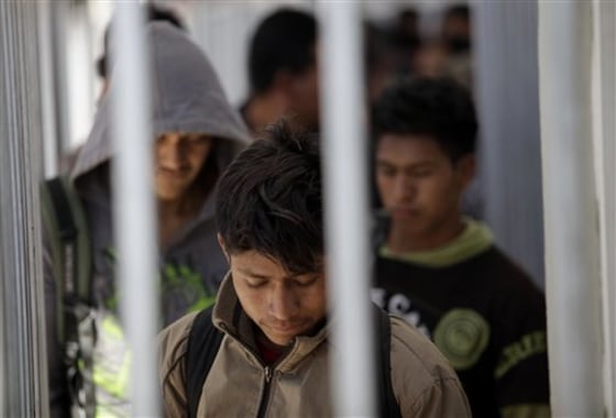 Men recently deported from Arizona wait in line to be registered with Mexican authorities at the border in Nogales, Mexico, on April 28, 2010. 